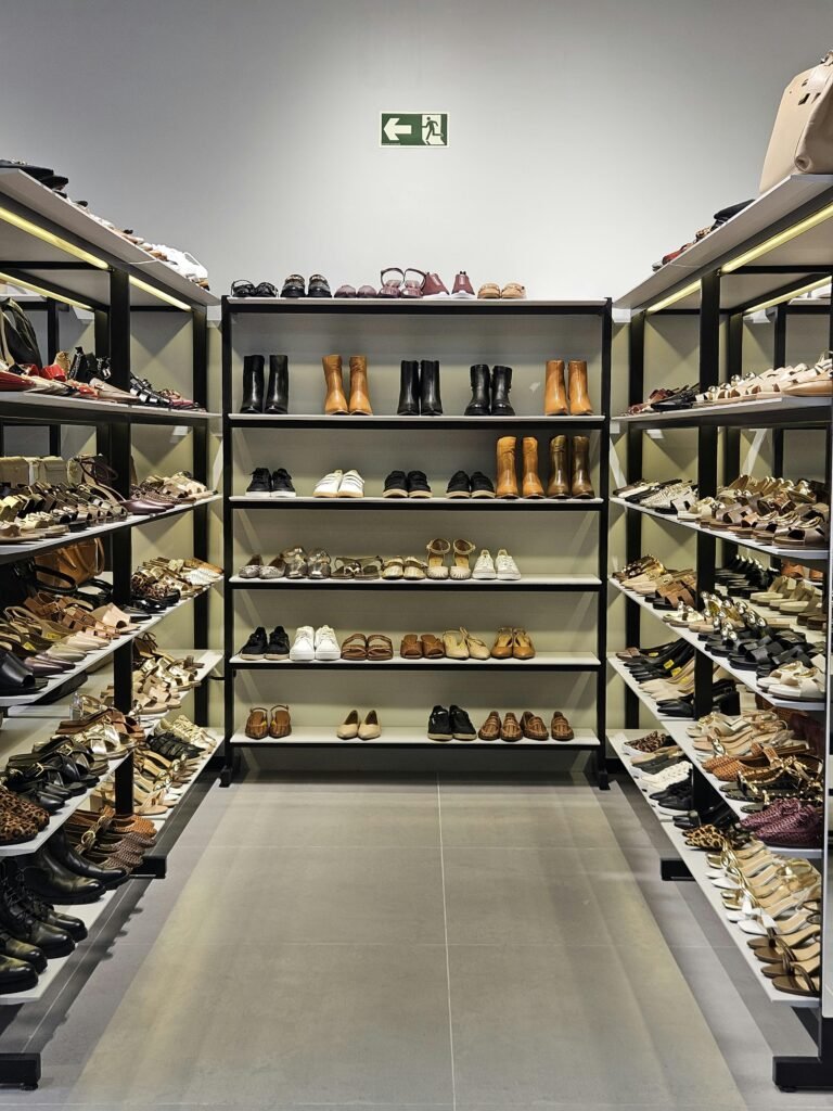 Explore a well-organized shoe store aisle displaying various styles and sizes of modern footwear on shelves.